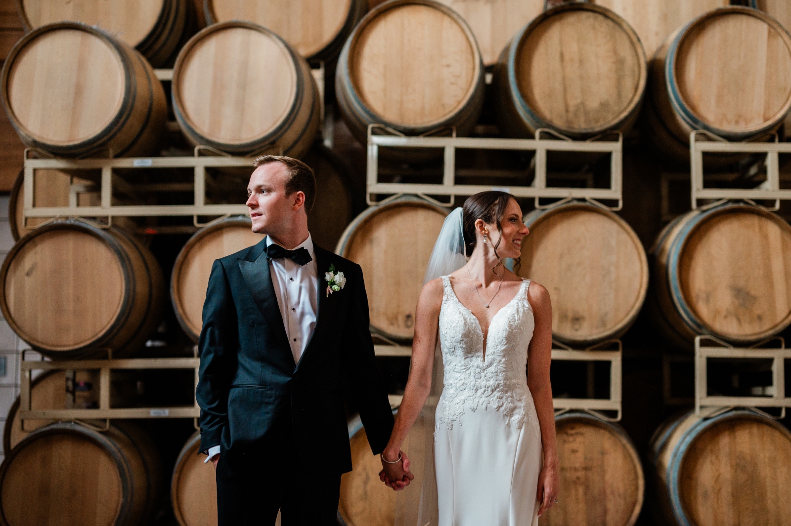 The bride and groom pose for couple's portraits in the Barrel Room at Jonathan Edwards Winery