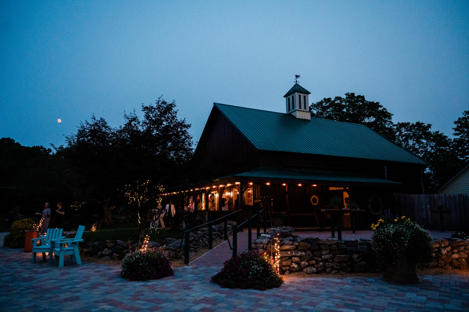 A view of the Salem Herbfarm reception building glowing warmly in the night darkness