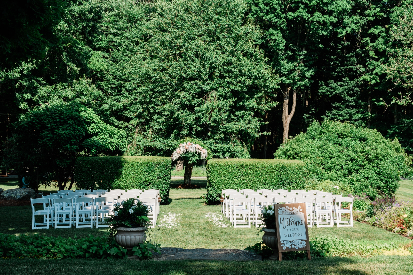 A wedding ceremony set up with white folding chairs at Smith Farm Gardens