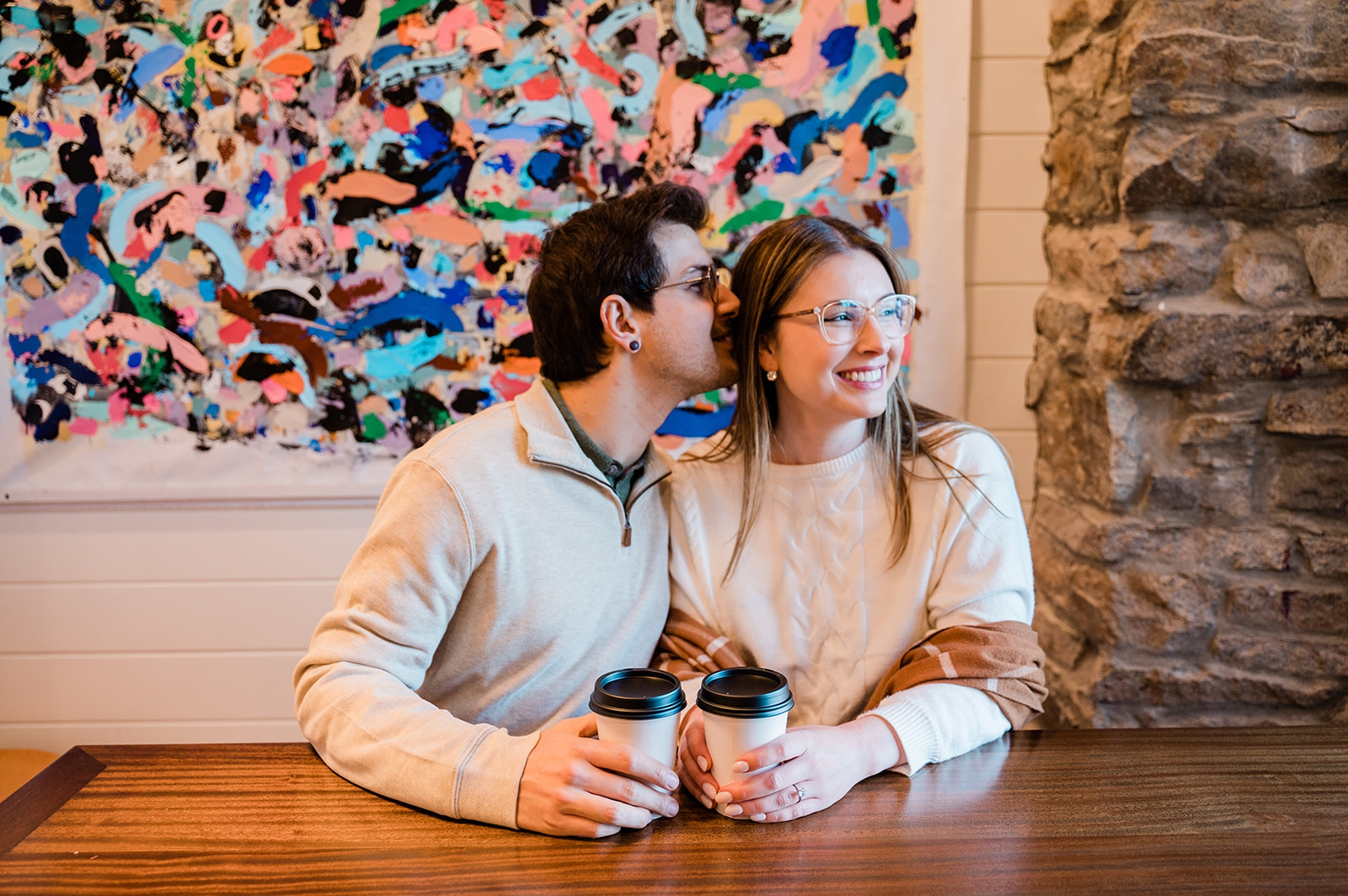 A man and woman take engagement photos in a coffee shop in Newport, Rhode Island