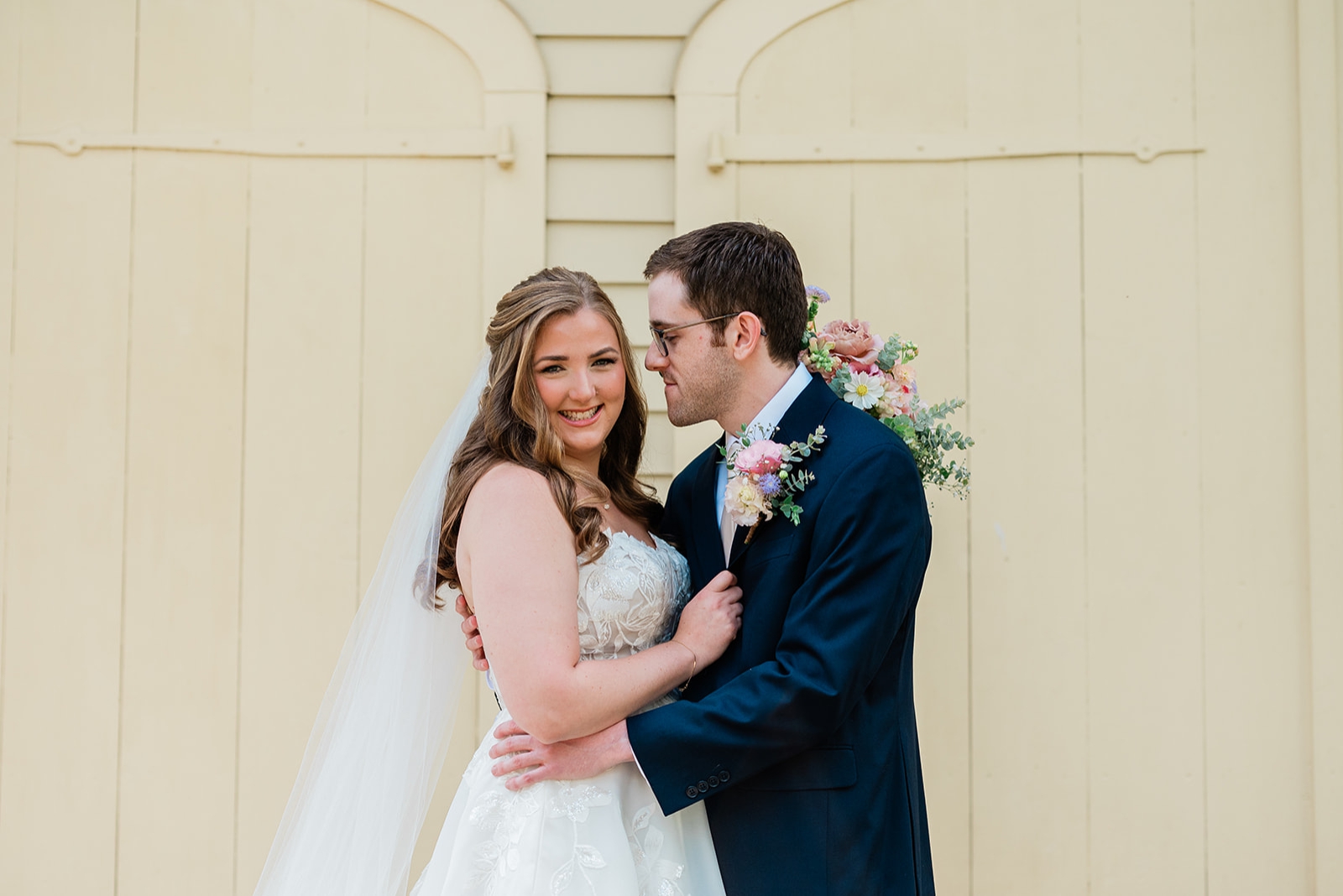 A groom looks at the bride and puts his hands on her waist