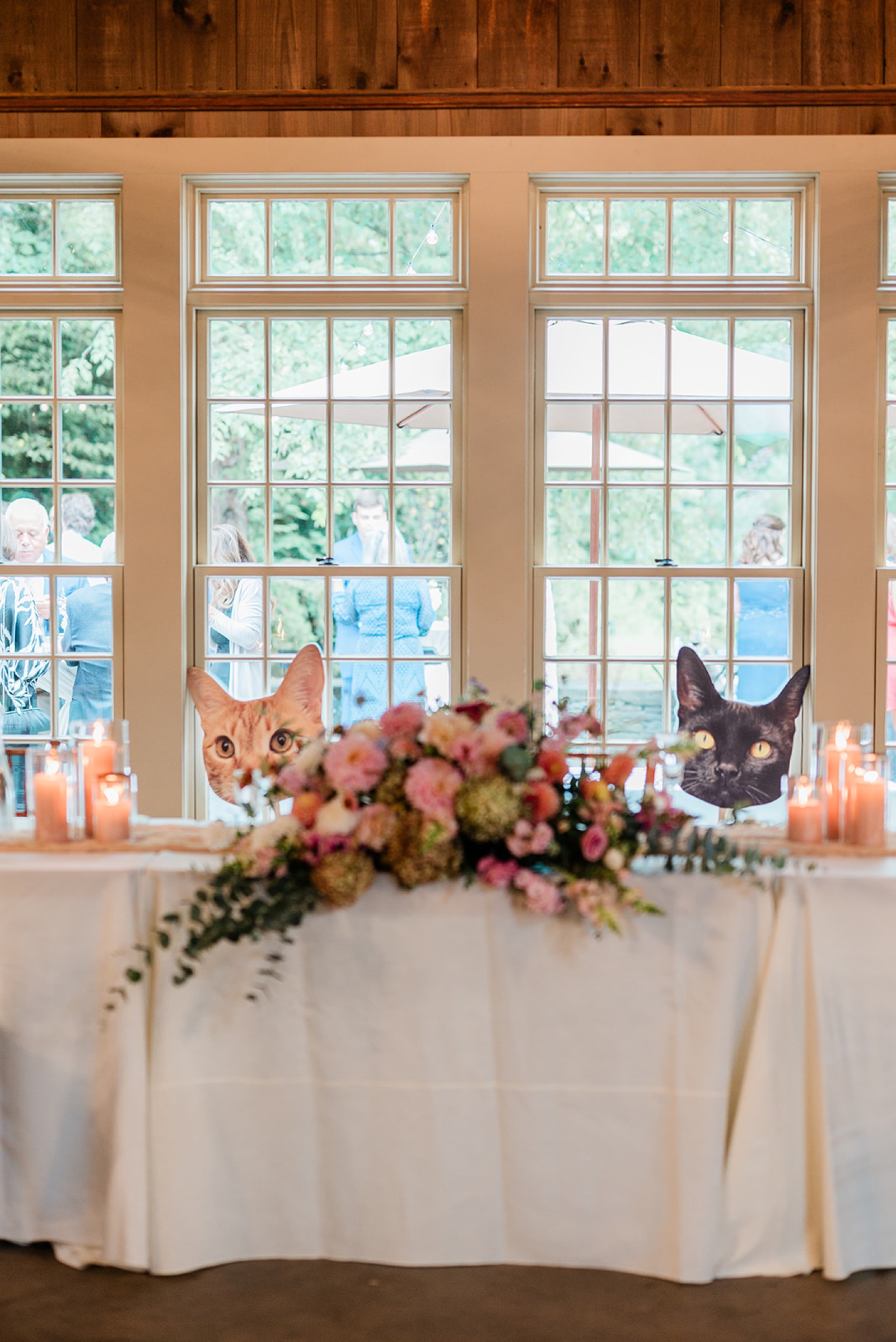 The sweetheart table at a wedding reception decorated with cardboard cut-outs of cat faces 