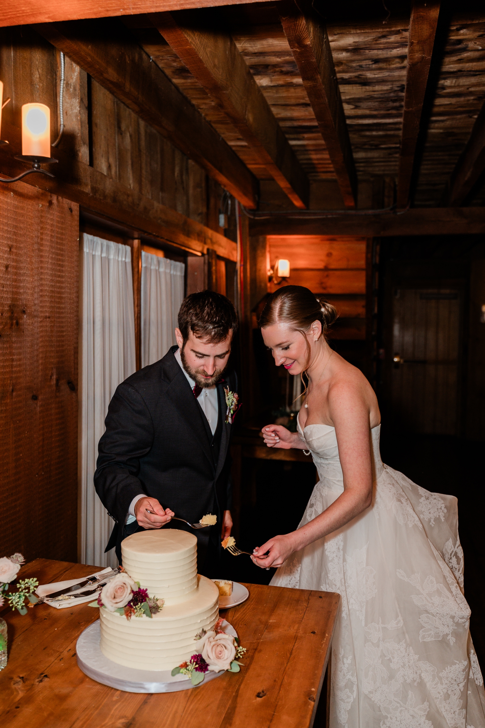 A bride and groom cut their wedding cake at their reception