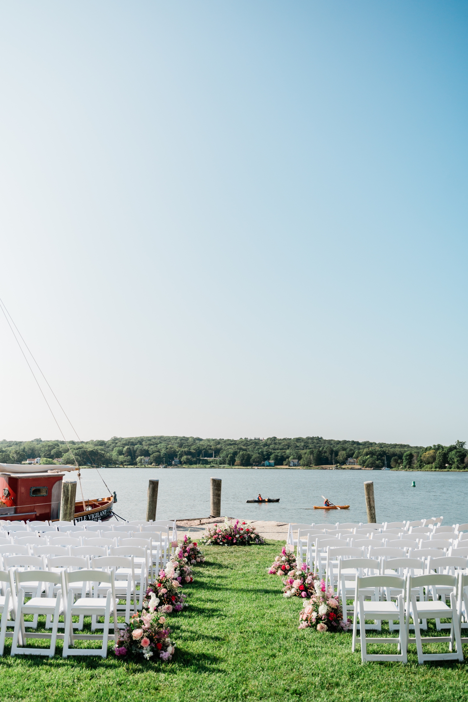 A weedding ceremony set up on the waterfront lawn at the Delamar Mystic