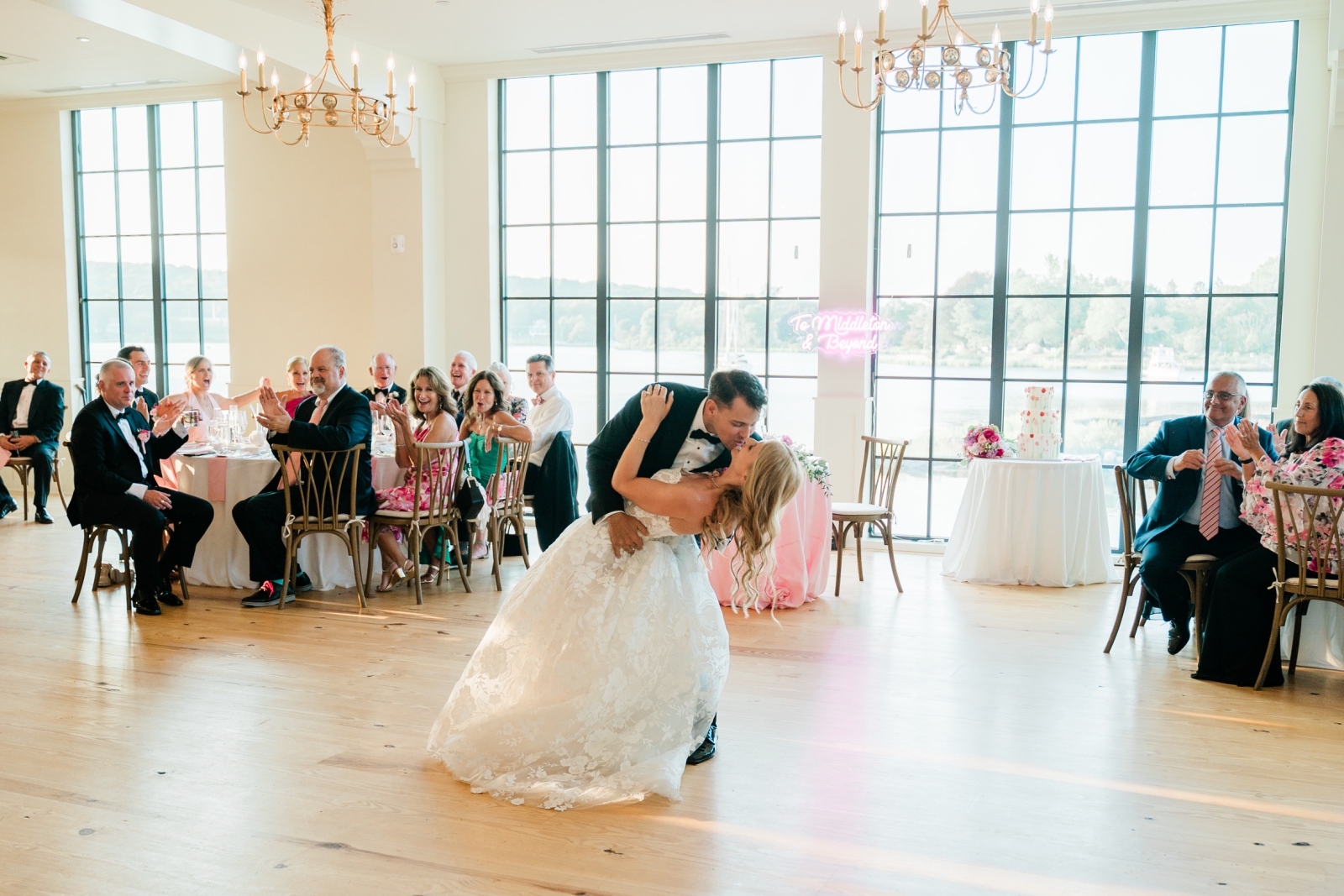 A groom dips his bride during their first dance at their wedding reception