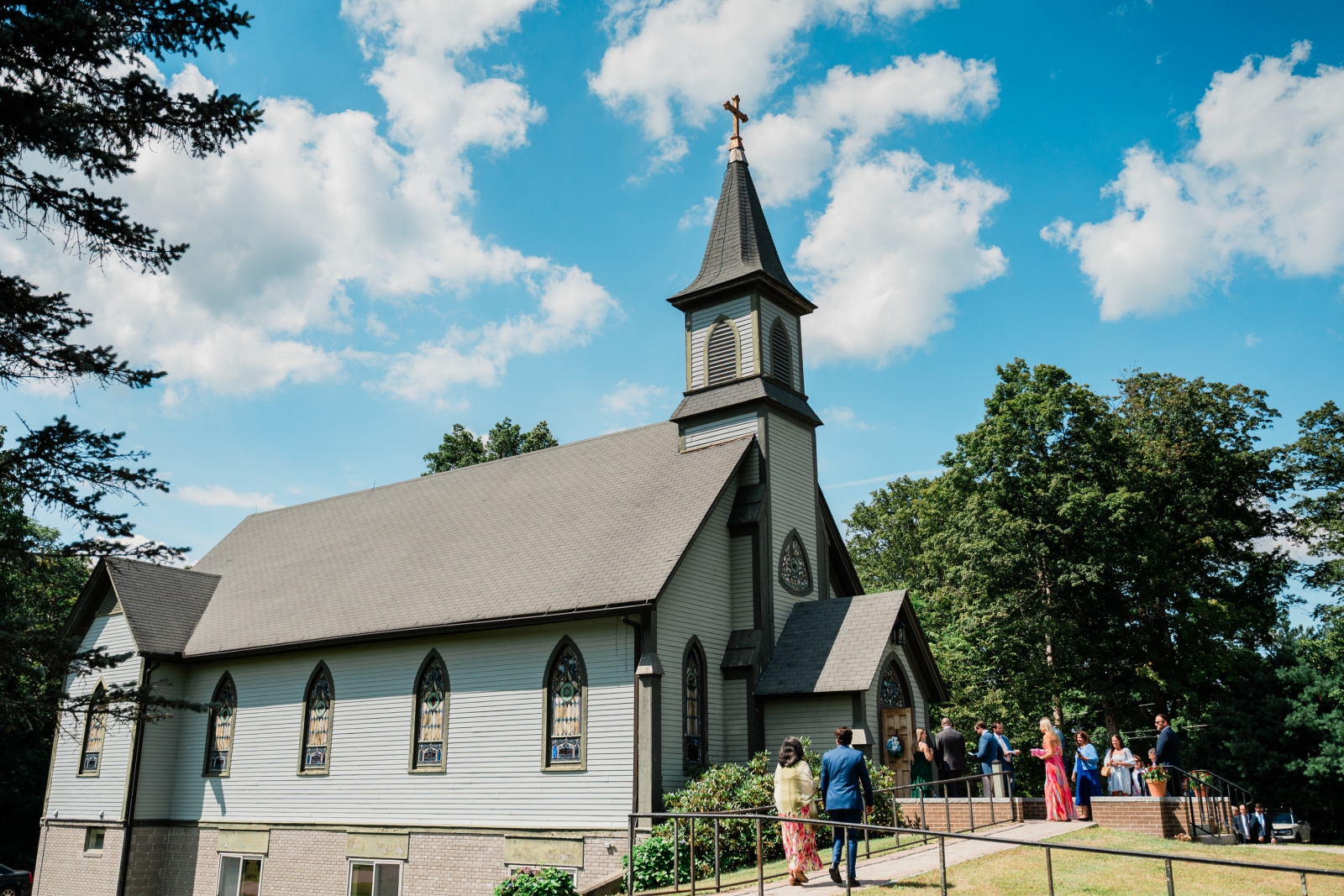The Most Holy Trinity Church in Pomfret, Connecticut, with arched stained glass windows and a tall bell tower