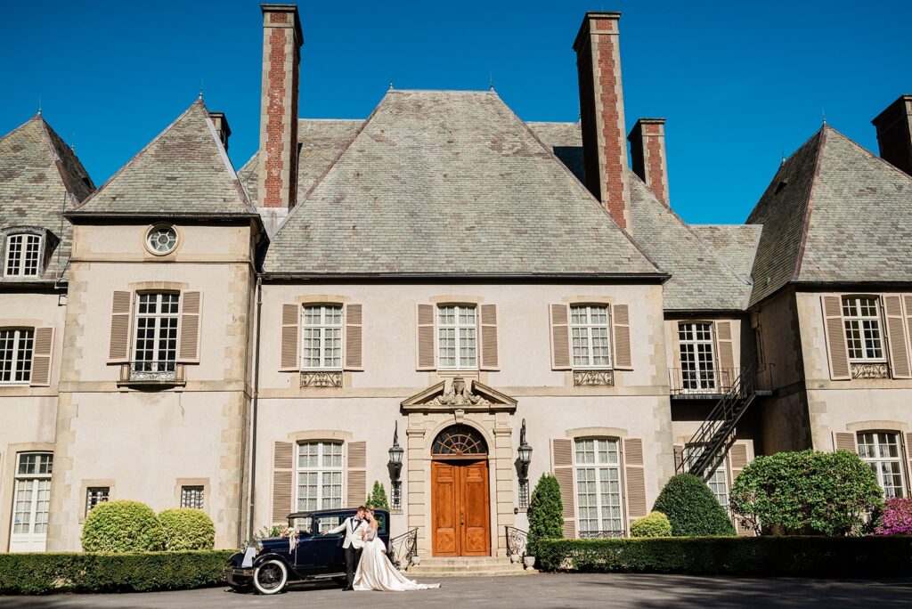 An antique car outside of the Glen Manor House, a large, French-inspired home with two brick chimneys